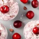 Family gathering around a bowl of sweet, creamy Cherry Fluff.