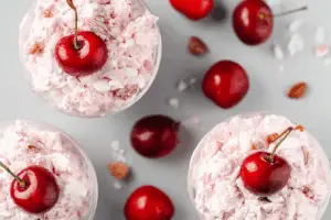 Family gathering around a bowl of sweet, creamy Cherry Fluff.