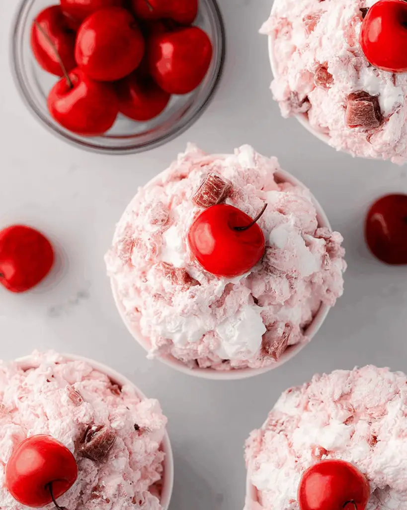 Different variations of cherry fluff recipe in serving bowls.