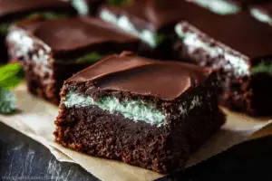 Stack of classic three-layer mint brownies with fresh mint