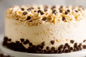 Creamy cannoli cake with chocolate chips on a cake stand