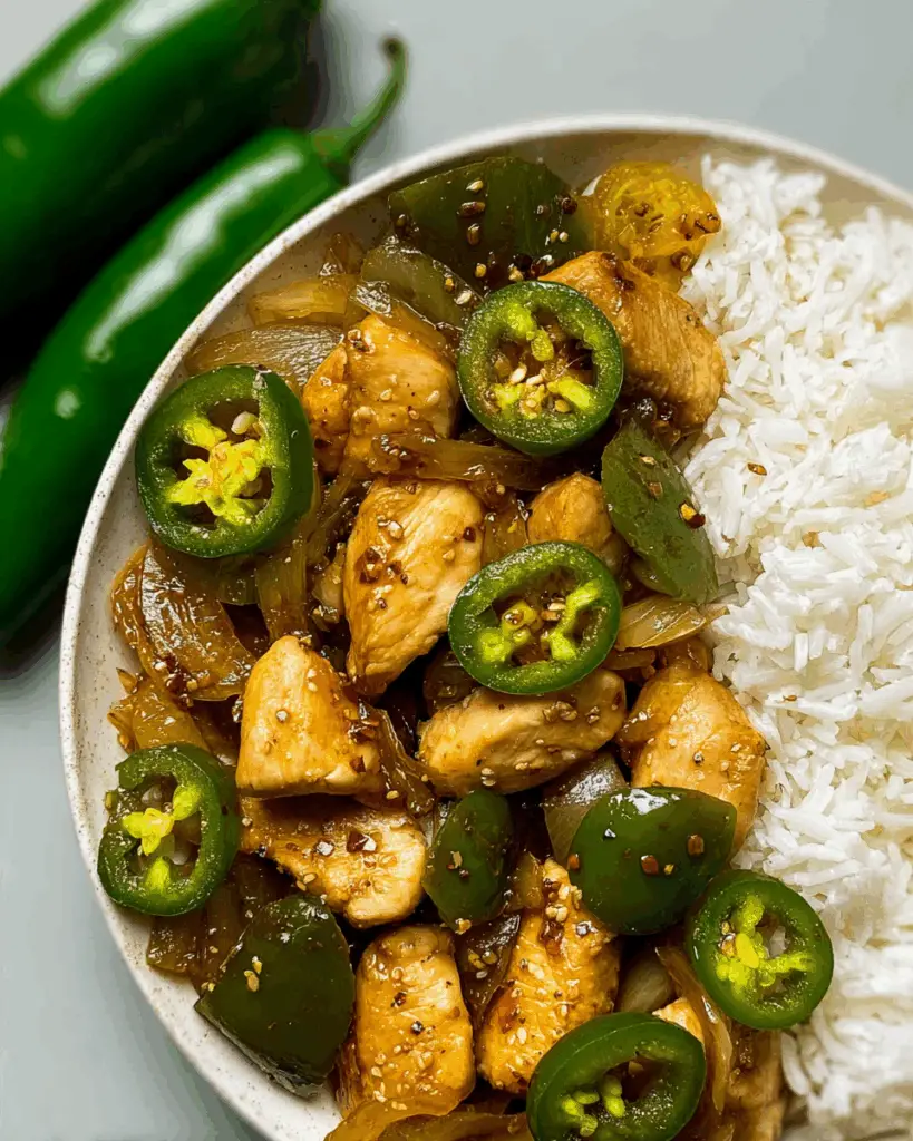 Stir frying chicken and jalapeños in a wok