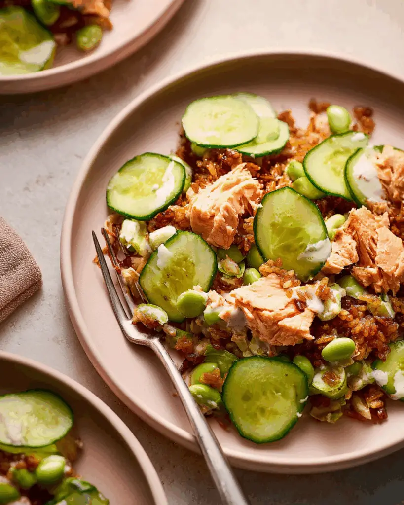 Assembling crispy rice salmon cucumber salad with creamy Asian dressing