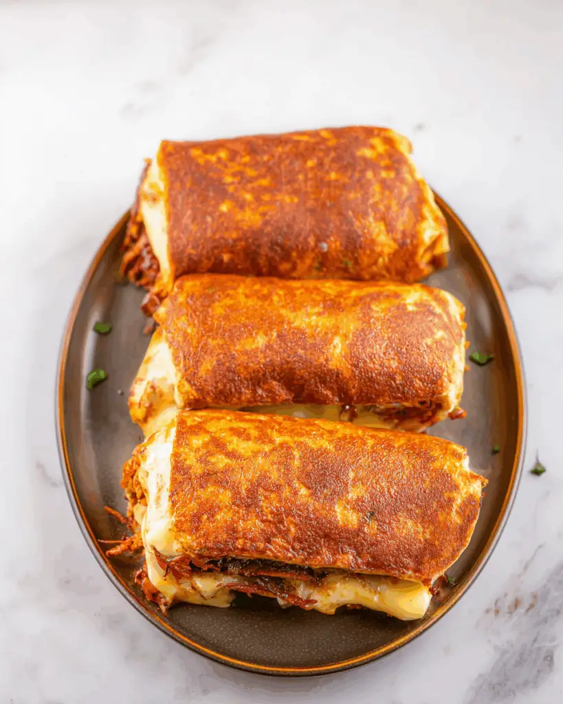 Plated grilled cheese burrito recipe with salsa and sour cream