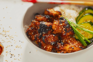 Korean BBQ Chicken sizzling on charcoal grill with smoky glaze