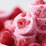 Raspberry Frozen Yogurt Bites with fresh raspberries on a plate