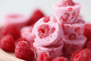 Raspberry Frozen Yogurt Bites with fresh raspberries on a plate